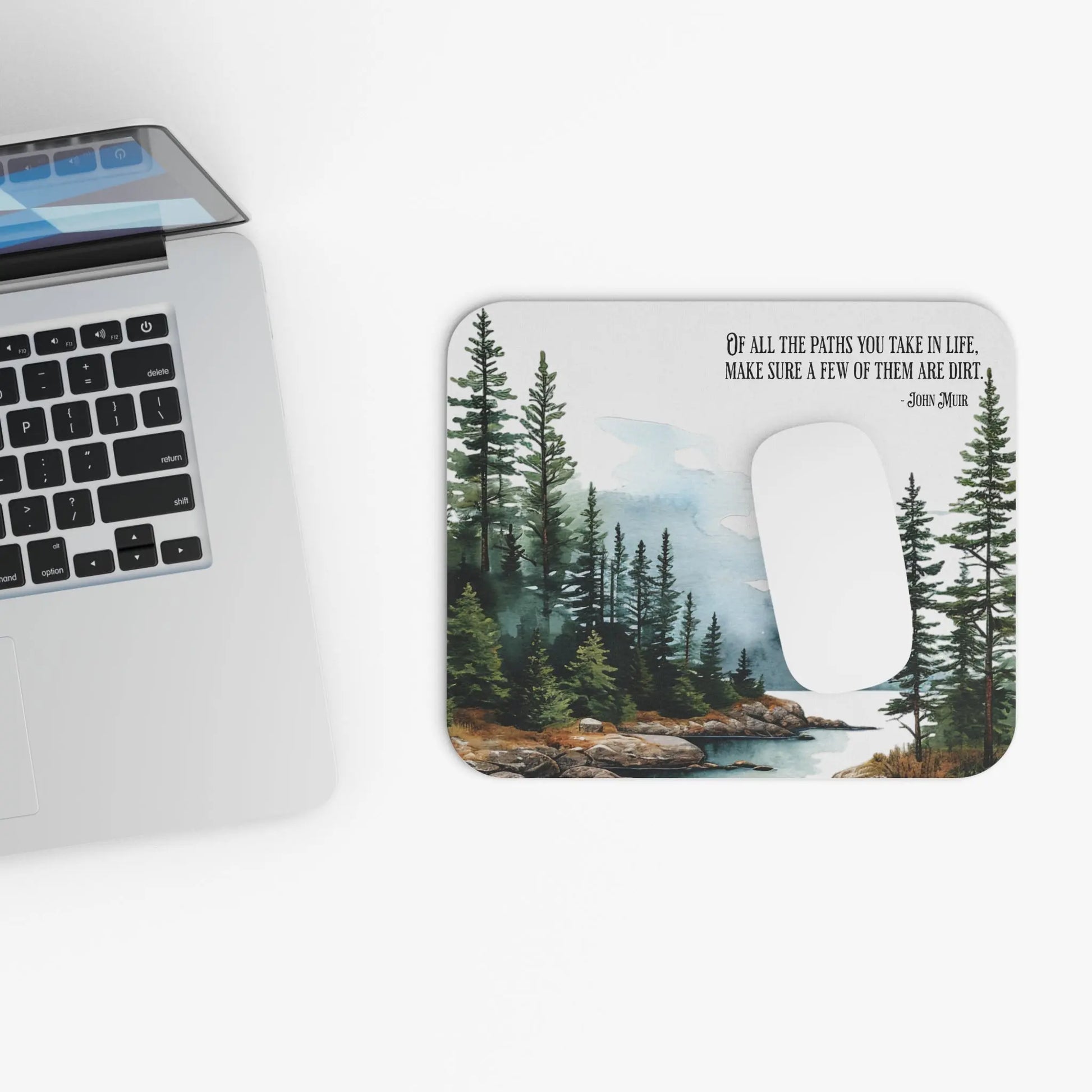 Laptop with a scenic mouse pad featuring trees and a lake.