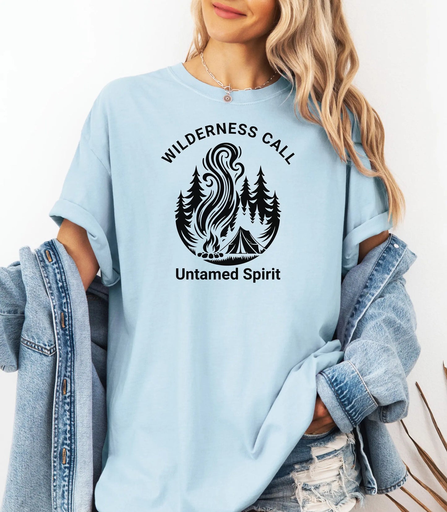 Light chambray t-shirt with 'Wilderness Call Untamed Spirit' design worn by a person.